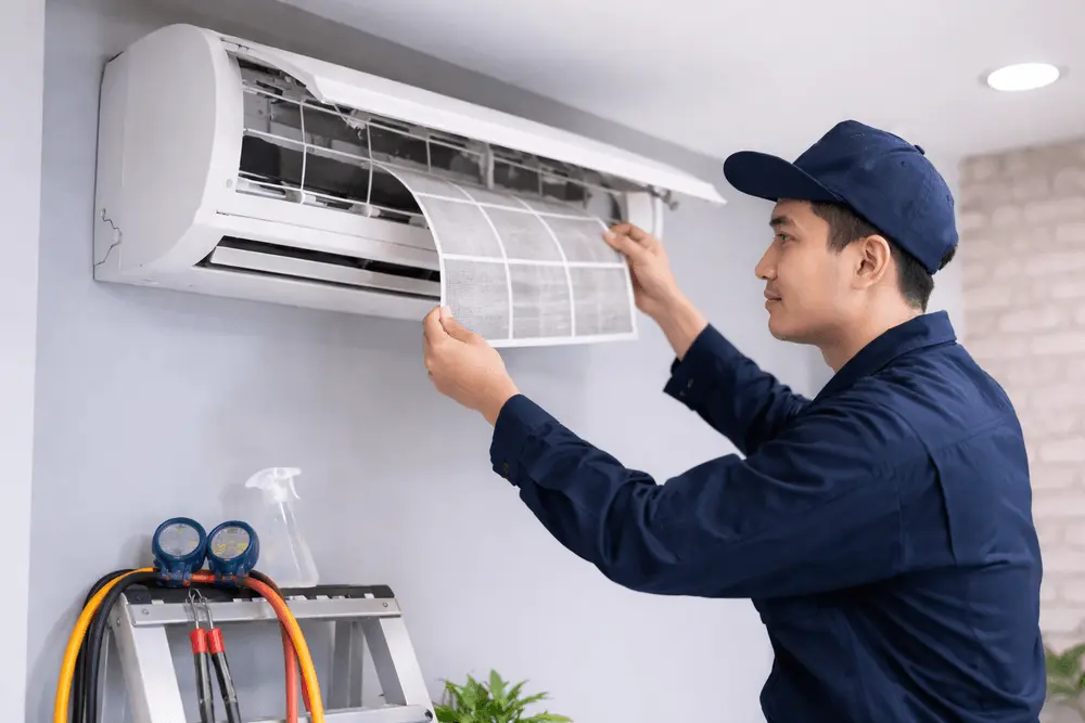 Technician cleaning aircond filter during regular aircond servicing in Malaysia